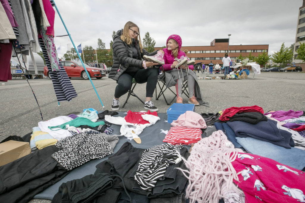 Kesäkirpputori torilla. Kaksi tyttöä ja vaatekasoja.