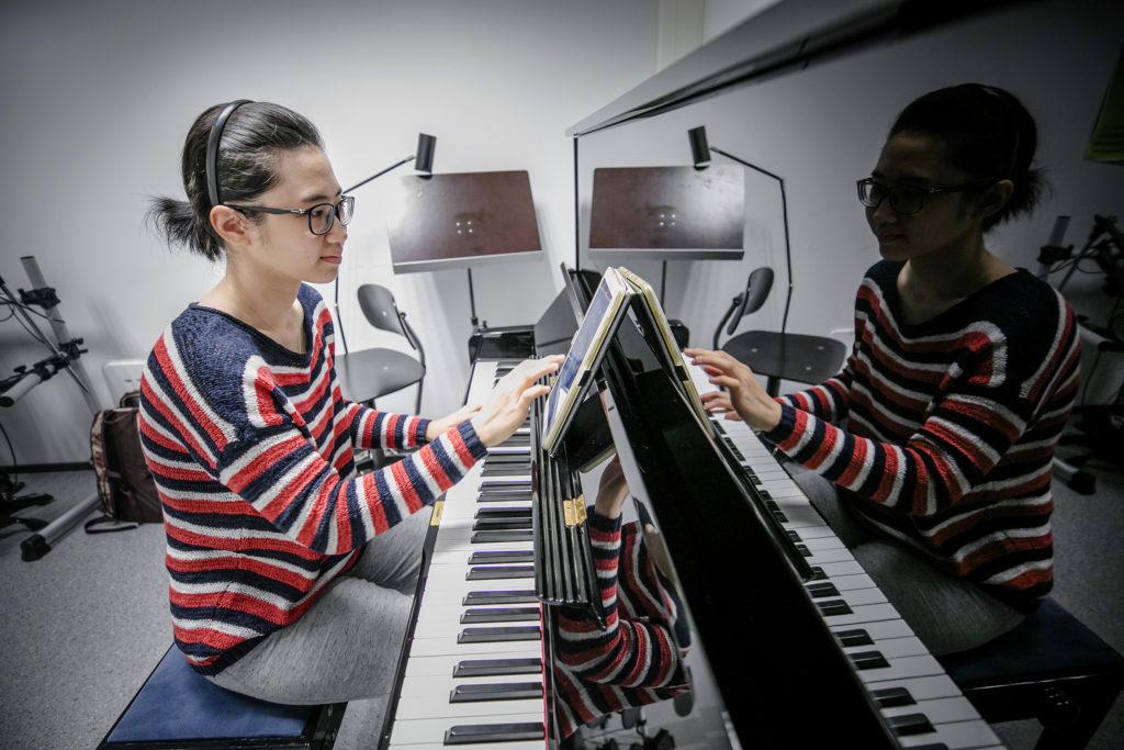 Kemin kaupunginkirjaston musiikkihuone. Pianoa soittamassa ammattikorkeakouluopiskelija Ngan Nguyen Vietnamista.