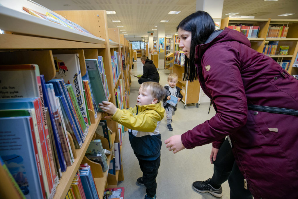 Aksila-Kaupin perhe kirjastossa. Etualalla Väinö Aksila ja Suvi Kauppi, taustalla Mika ja Leo Aksila.