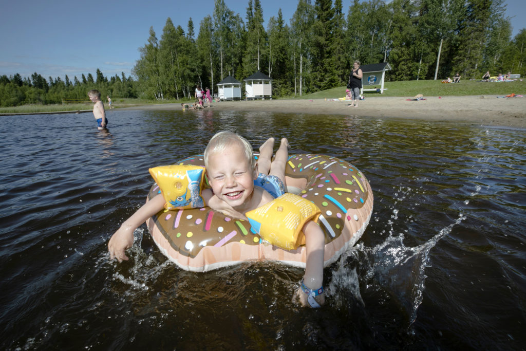 Pikkupoika uimassa, uimarengas mukana.