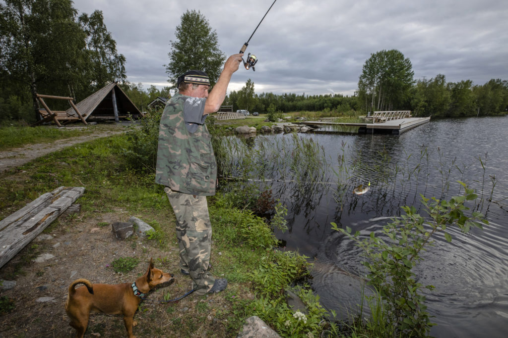 Mies virvelöimässä koiran kanssa merenrannalla.