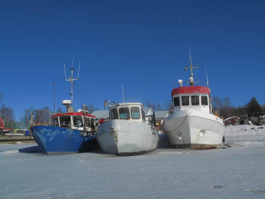 Veneitä satamassa jäiden keskellä.