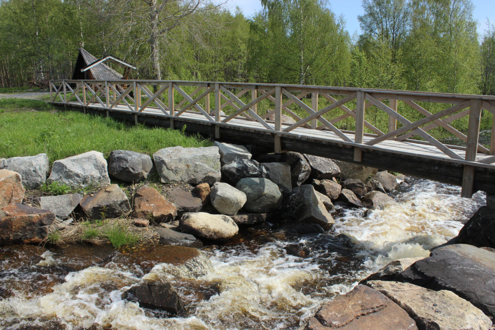 Kuohuava puro ja sen päällä puusilta.