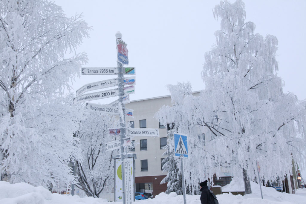 Talvinen kuva ystävyyskaupunkien tienviitoista kaupungintalon edustalla.