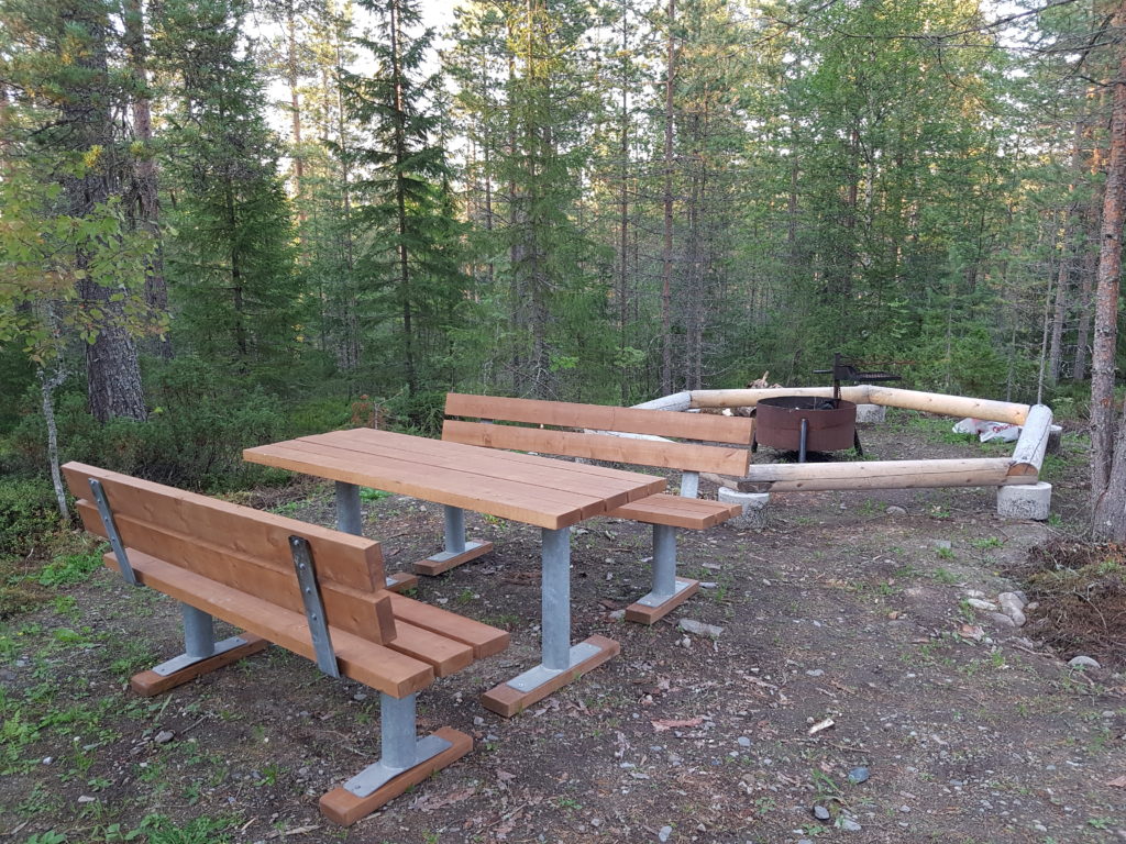 Tulistelupaikka metsässä, vierellä pöytä ja penkit.