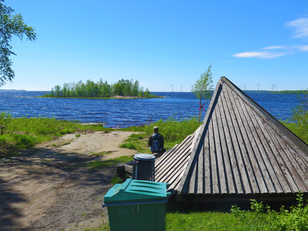 Mies istuu Satamakankaan laavulla ja katselee merta, aurinko paistaa ja taitaa vähän tuullakin.