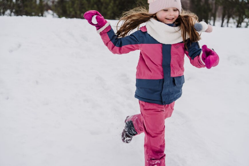 Lapsi juoksee lumessa.