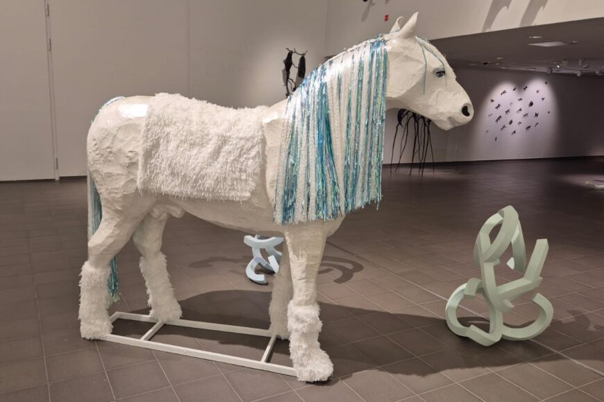 Avarassa tilassa valkoinen hevospatsas, jolla on on pitkä kimaltava häntä ja harja.