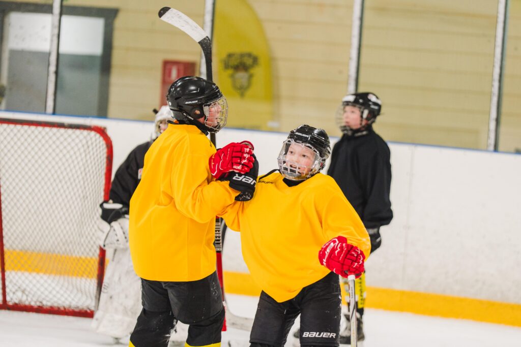Nuoria jääkiekkoilijoita kaukalossa.
