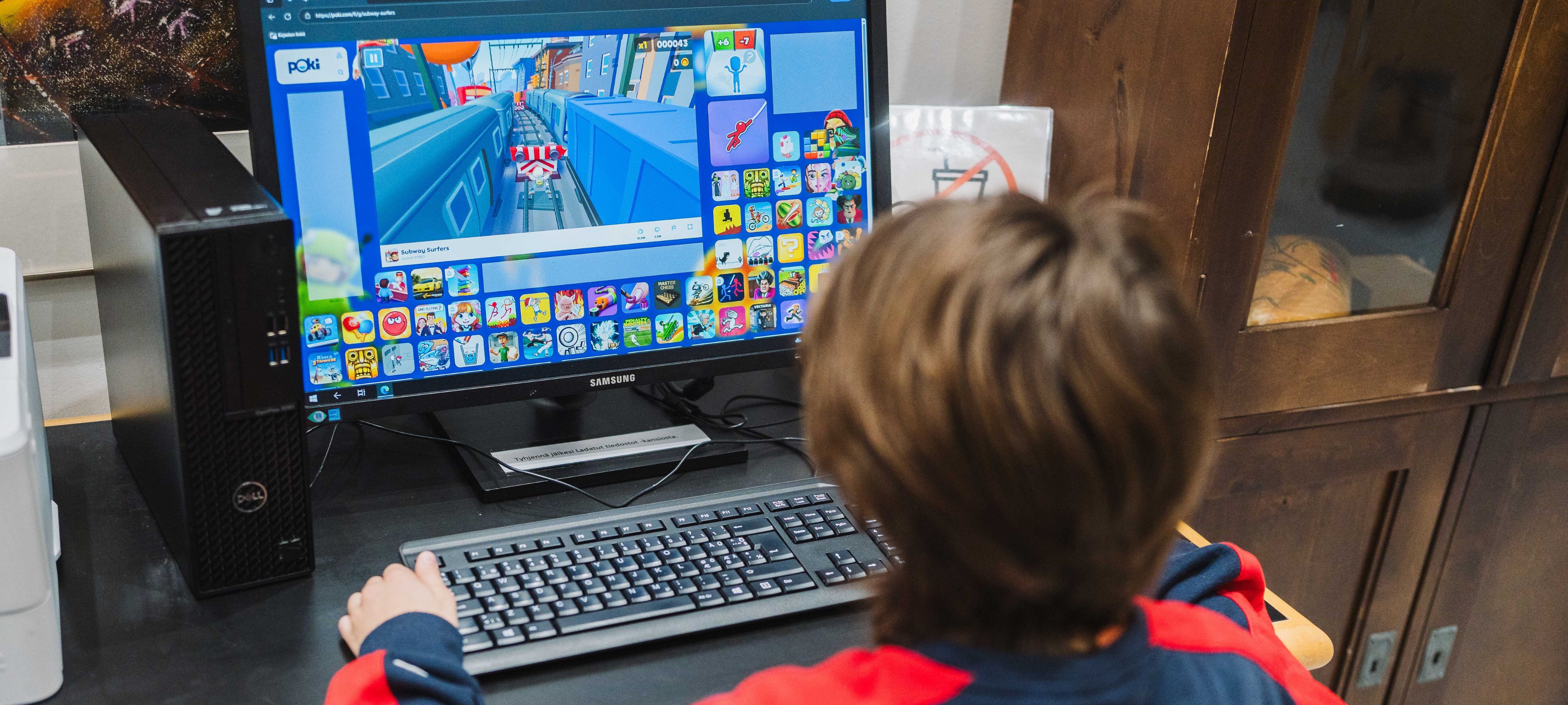 Lapsi pelaa tietokoneella.